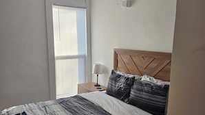 Camera da letto con un letto, un comodino, una lampada e un condizionatore.