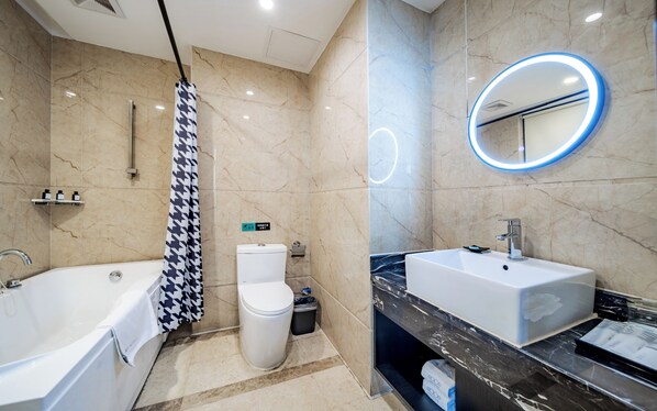 Un bagno moderno con vasca, servizi igienici e mobile lavabo con specchio.
