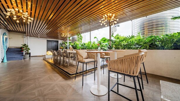 A modern indoor space with wooden slatted ceilings, bar seating, and a view of greenery outside. - XANA Lite Hotel International Guangzhou Baiyun Railway Station Sanyuanli Branch - Free Deliver Service to Canton Fair Complex During Canton Fair Period (Guangzhou)