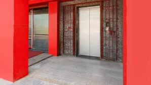 A red building facade with two doors, one with a metal gate and the other with a white door. - Hotel O Deendayal Crossway Ranchi (Ranchi)