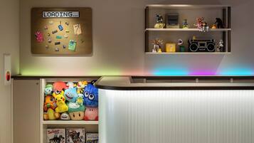 Una habitación con un tablón de anuncios, estantes con figuritas, peluches y un armario blanco.
