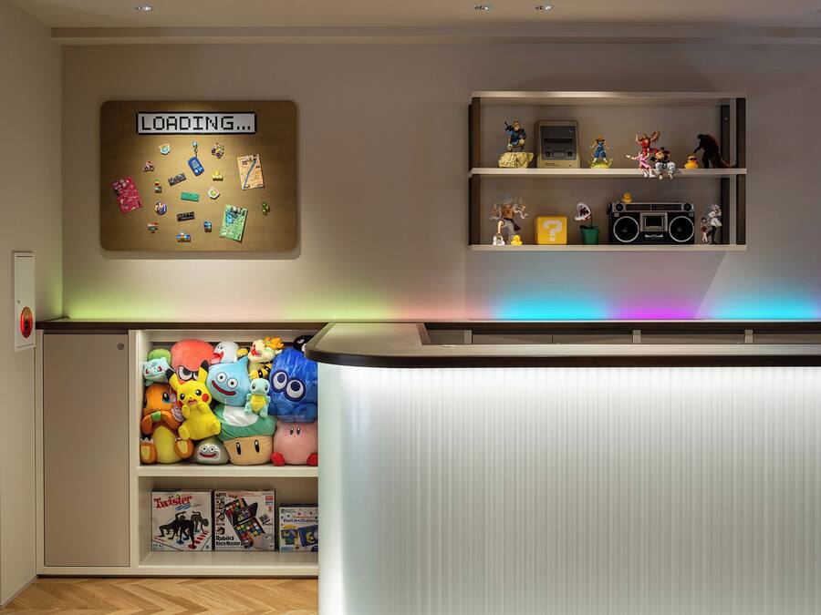 Una habitación con un tablón de anuncios, estantes con figuritas, peluches y un armario blanco.