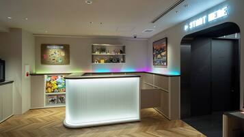 A modern interior with a central counter, wooden flooring, and a neon sign.