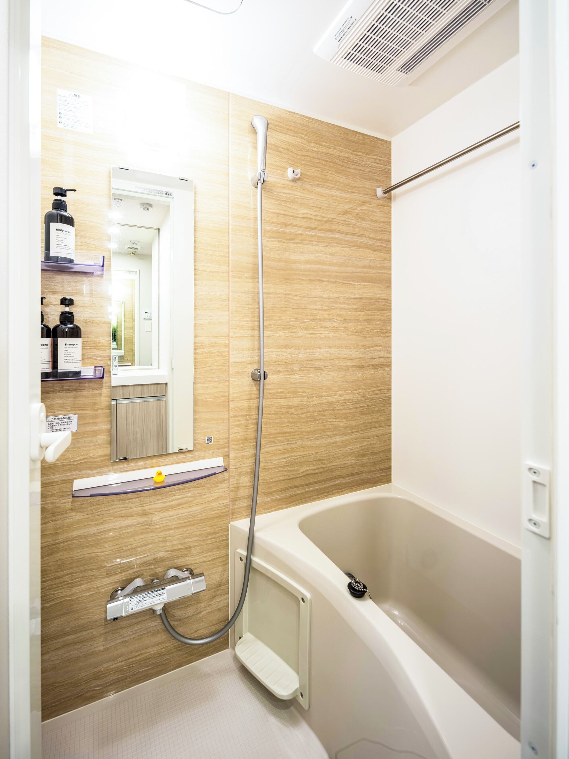 Een moderne badkamer met een badkuip, douche en een wastafel met planken.