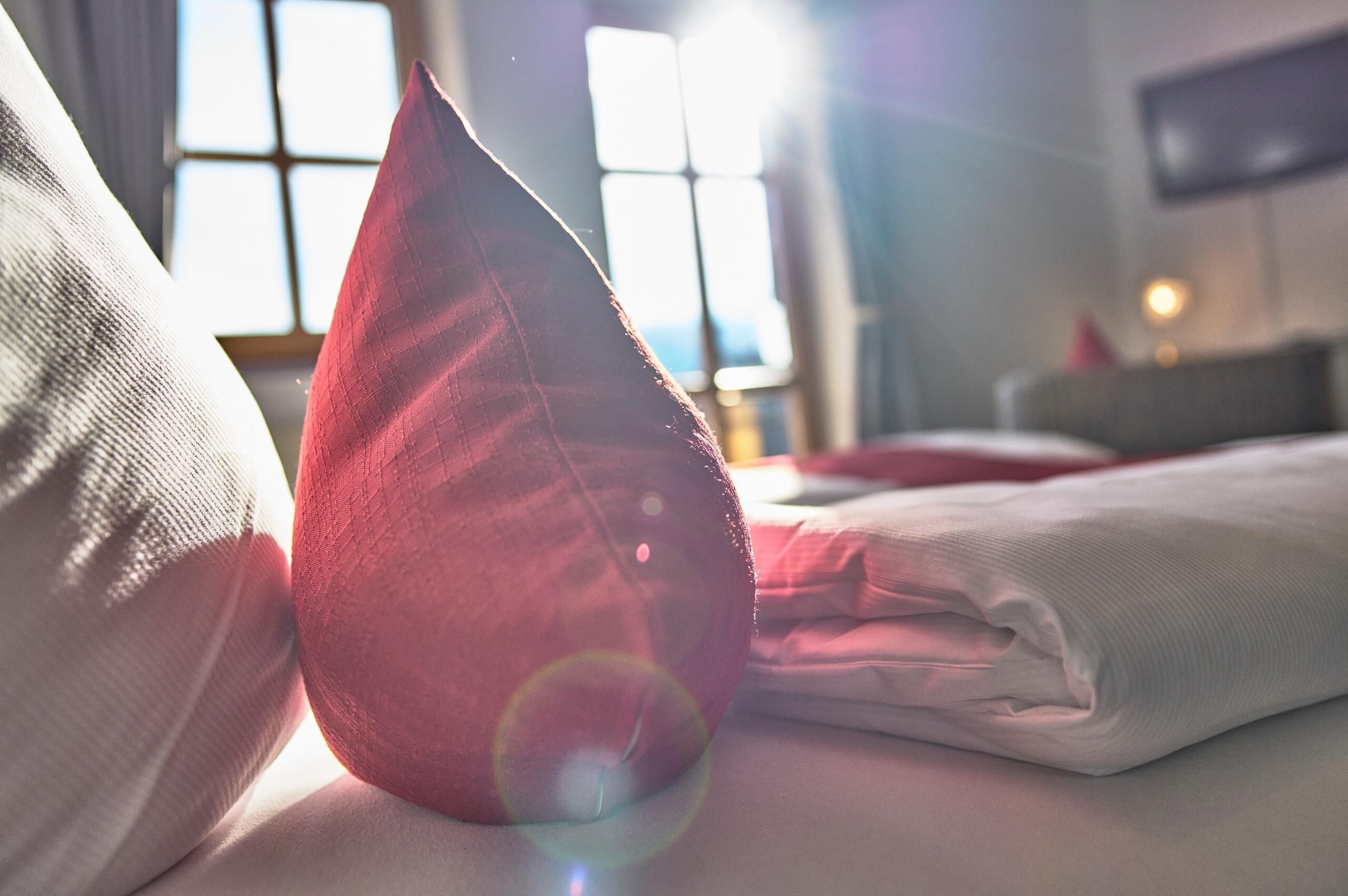 Una cama con almohadas y un edredón cuidadosamente doblado.