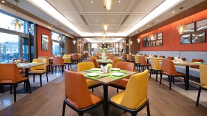 A spacious restaurant with multiple dining tables and chairs, large windows, and modern pendant lighting. - Hampton by Hilton Beijing Wuzi Xueyuan Road (Tongzhou)