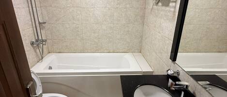 Une salle de bain avec une baignoire, des toilettes, un lavabo et une douche.