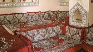 A traditional room with ornate mirrors, patterned cushions, and decorative wall hangings. - Harari Guest House  (Harar)
