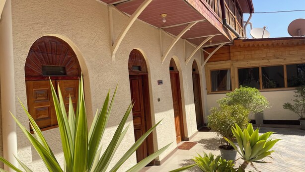 A building with arched doorways and a balcony with wooden railings. - Harari Guest House  (Harar)