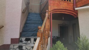 A staircase with a wooden handrail leading to a balcony with a wooden railing. - Harari Guest House  (Harar)