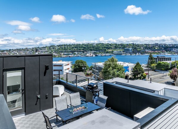 Une terrasse sur le toit, avec un jeu d’échecs, des sièges et une vue sur le paysage urbain du port.