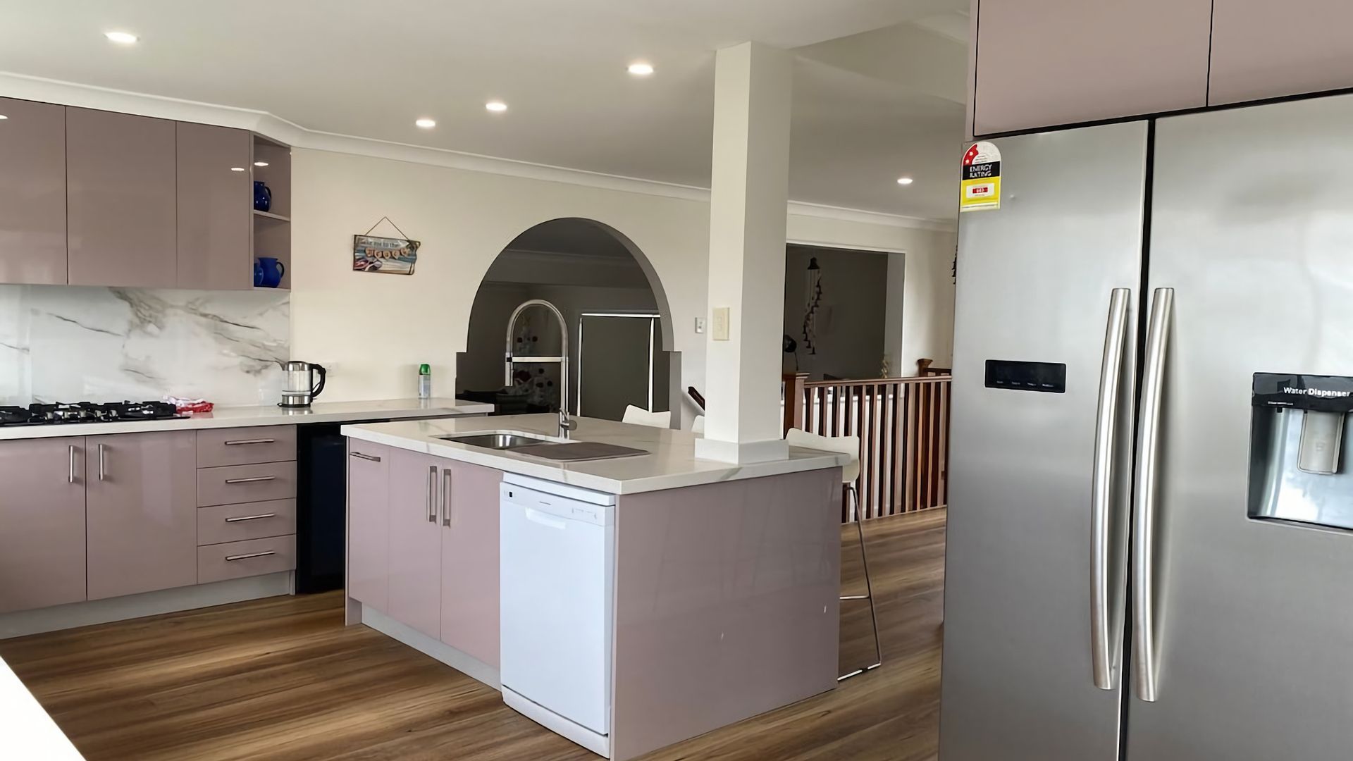 A modern kitchen with a central island, stainless steel appliances, and a water dispenser.