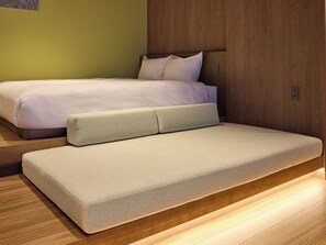 Une chambre moderne avec un lit, un canapé-lit et un plancher en bois.
