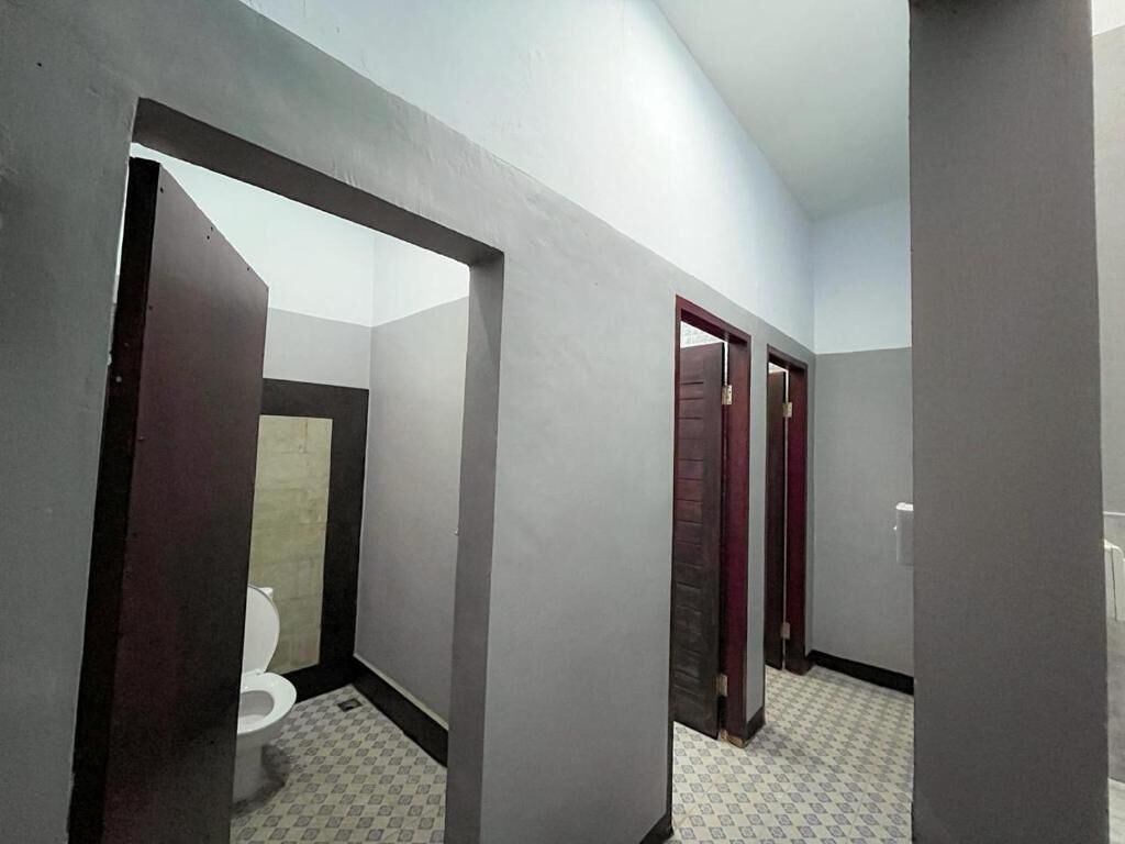 A hallway with a toilet, a door, and a patterned floor.