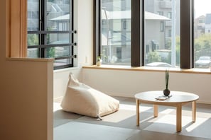 A room with tatami flooring, a low table with a vase, and a window with a view of buildings. - Newly built 3LDK house with rooftop for rent | 7m / Katsushika Ward Tokyo (Katsushika Ward)