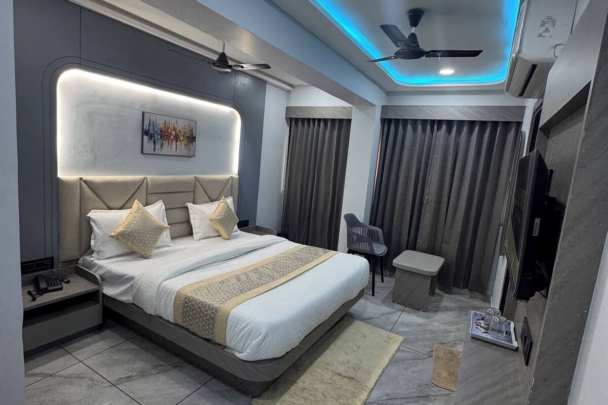Ein modernes Schlafzimmer mit einem großen Bett, Nachttischen, einem Schreibtisch und einem Deckenventilator.