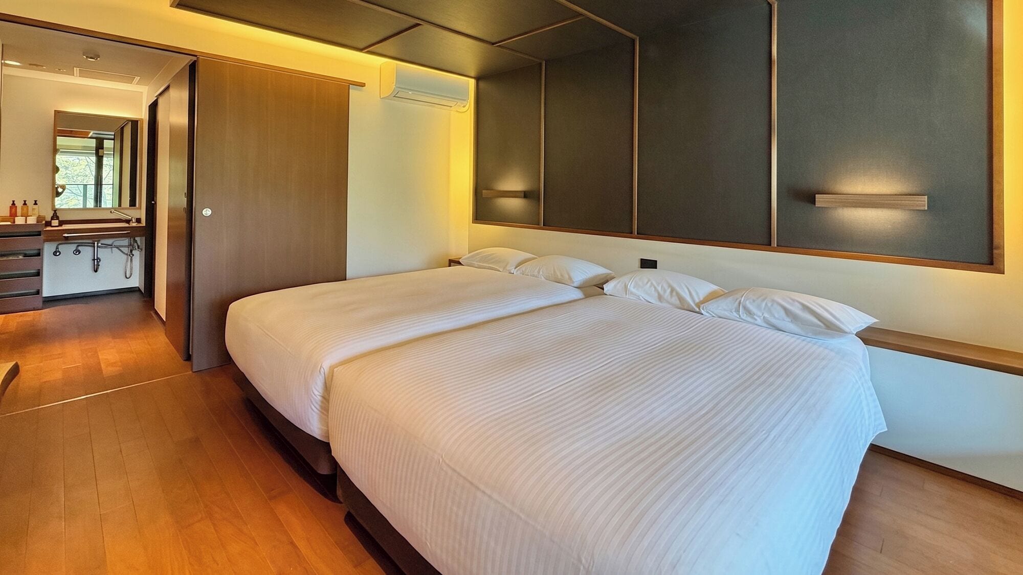Habitación de hotel con cama grande, armario empotrado, baño con ducha y vistas al exterior.