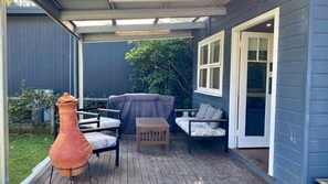 A covered patio with outdoor furniture, a grill, and a large planter. - Nautilus is pet friendly in North Bendalong (Bendalong)