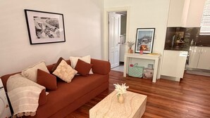 Un salon avec un canapé marron, une table basse et un tableau encadré accroché au mur.