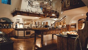 A spacious kitchen with a central island, wooden cabinetry, and a decorative chandelier. - Gams - apartment - balcony with mountain view, fireplace - 65sqm, non-smoking (Ramsau bei Berchtesgaden)