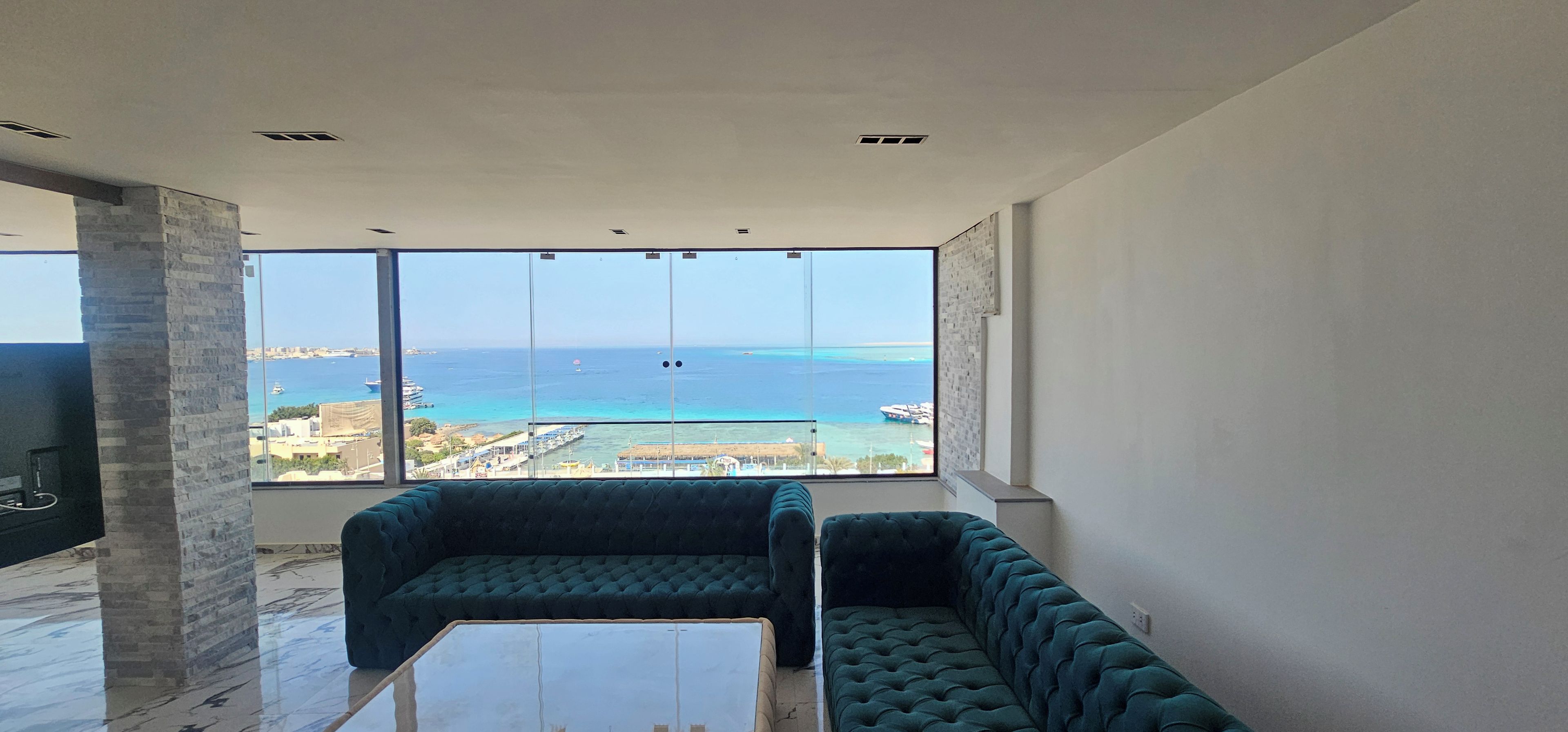 Sala de estar moderna com uma grande janela e vista para a costa.