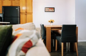 A modern kitchen with wooden cabinets and a black refrigerator.