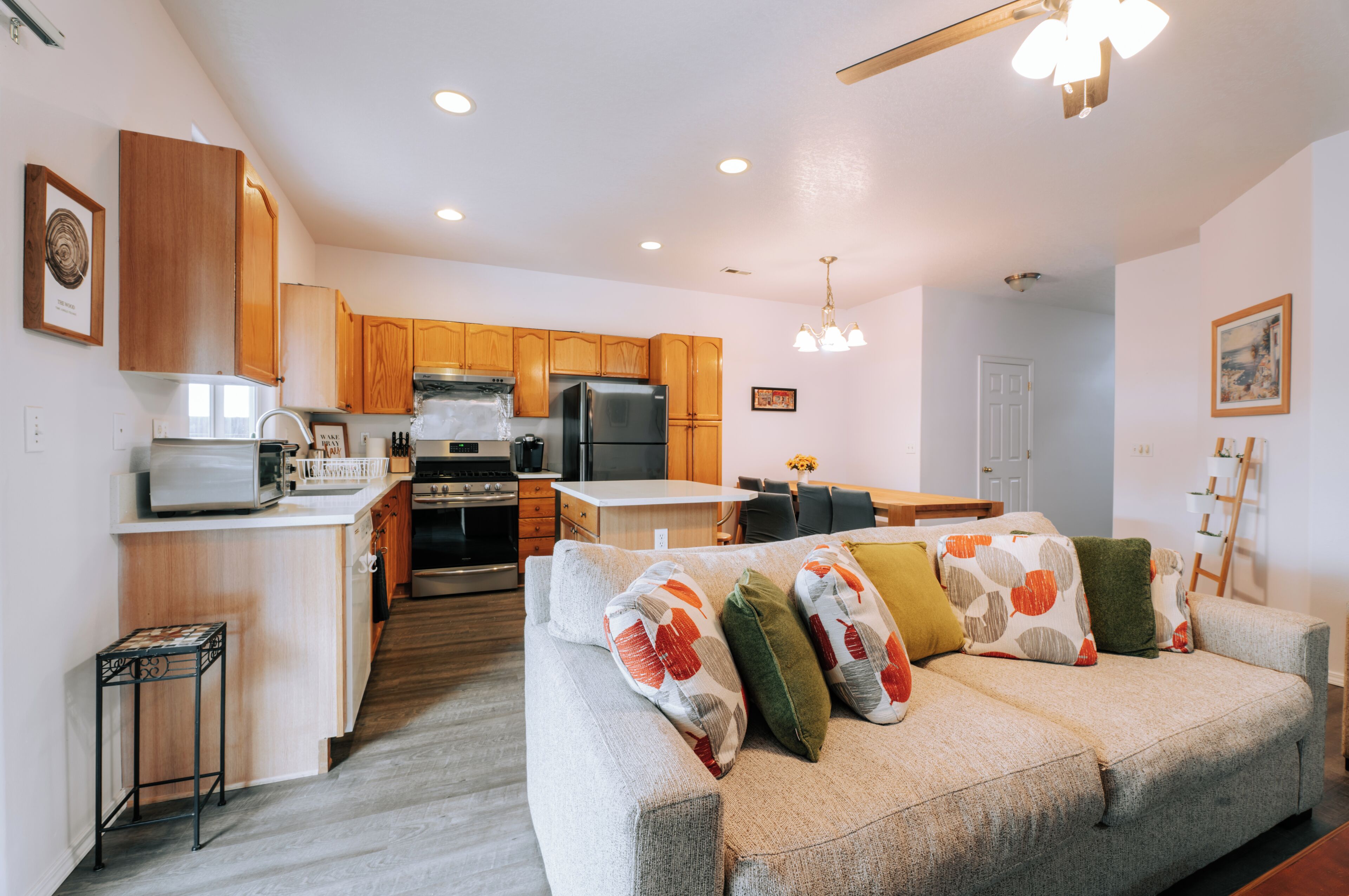 A modern kitchen with wooden cabinets, stainless steel appliances, and a dining area with a table and chairs.