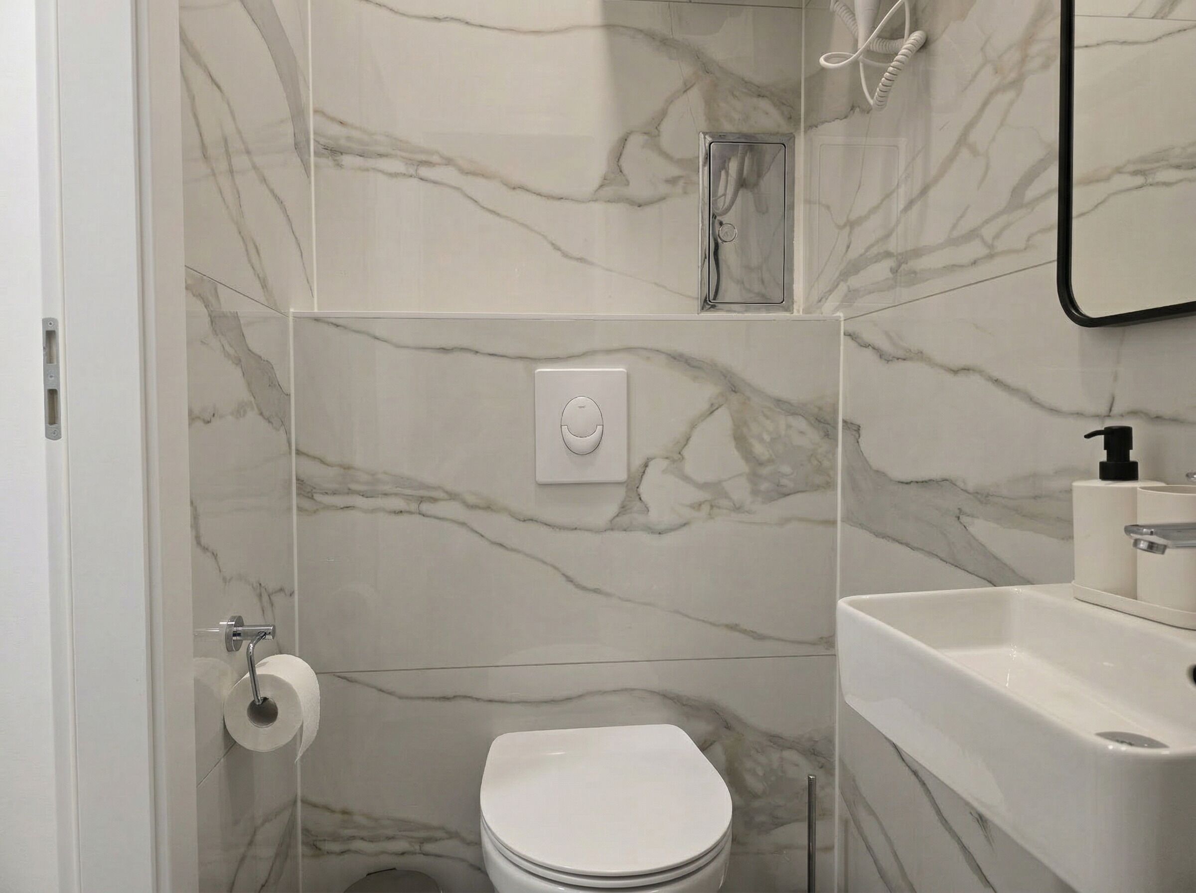 A bathroom with a toilet, a shower, and a sink.