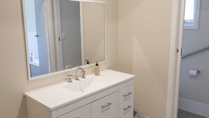 Un bagno con un mobile lavabo bianco, uno specchio grande e un water.