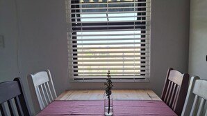 Una habitación con una mesa de madera, mantel púrpura y sillas.