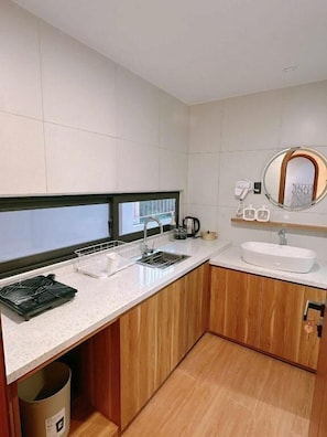 Een moderne badkamer met een wastafel, spiegel en zeepdispenser.