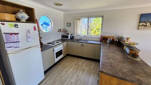 Una cucina compatta con frigorifero, fornello, forno a microonde e lavello.