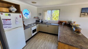 Eine kleine Küche mit Kühlschrank, Herd, Mikrowelle und Spüle.