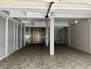 A spacious, modern interior with a high ceiling, a central pillar, and a view into a parking area. - Residence at 49 (Bangkok)