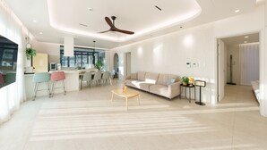 Un salon moderne comprenant un canapé, une table basse et un coin repas avec des chaises.