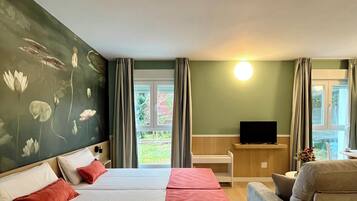 Ett hotellrum med två sängar, en TV, en soffa och utsikt över omgivningarna.