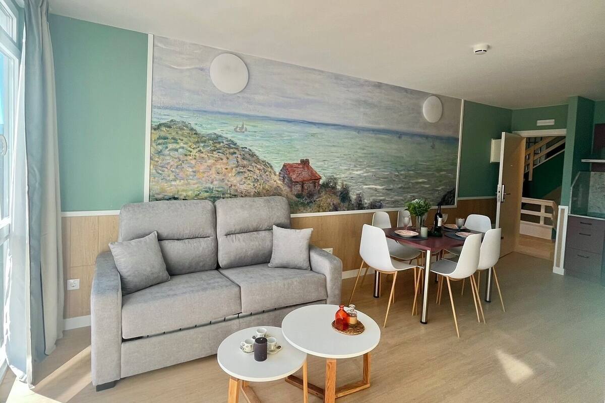 Un salon comprenant un canapé, deux petites tables rondes et un coin repas avec des chaises.