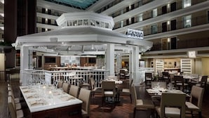 A multi-level restaurant with a central bar area, multiple dining tables, and a modern interior design. - Everything You Need For The Perfect Vacation! Breakfast, Pool, Pets Welcome! (Orlando)