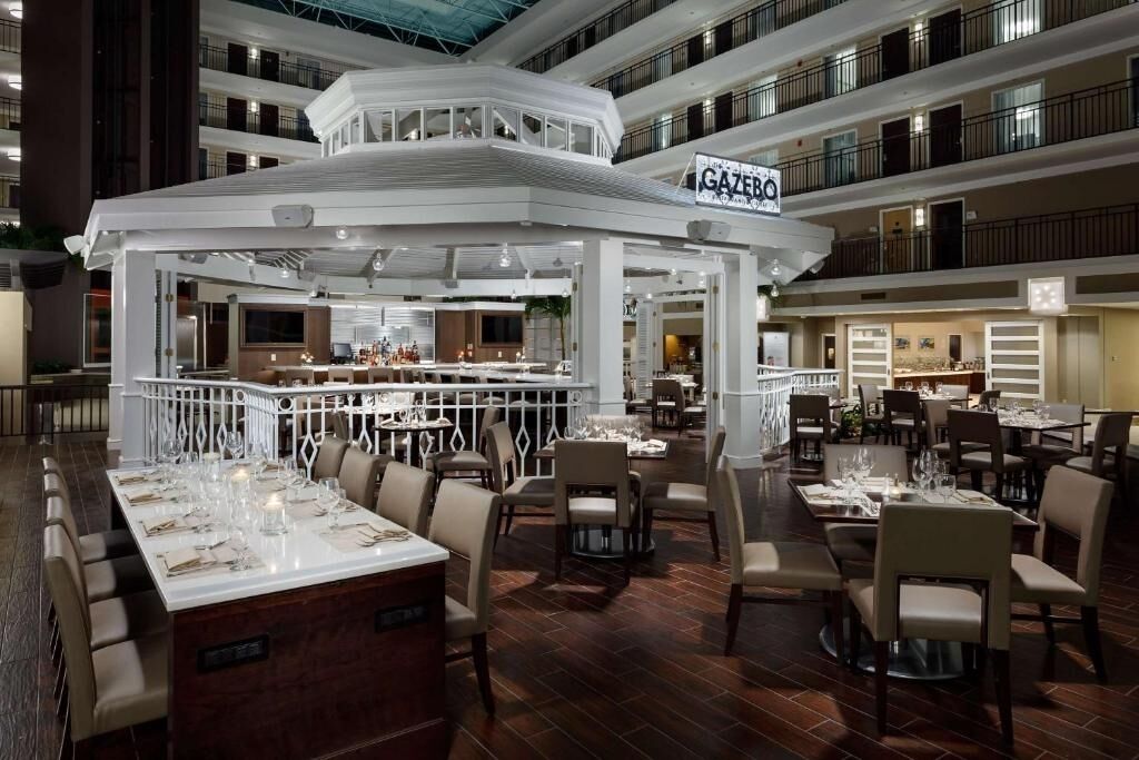 Un restaurant à plusieurs niveaux, doté d’un bar central, de nombreuses tables et d’un décor intérieur moderne.