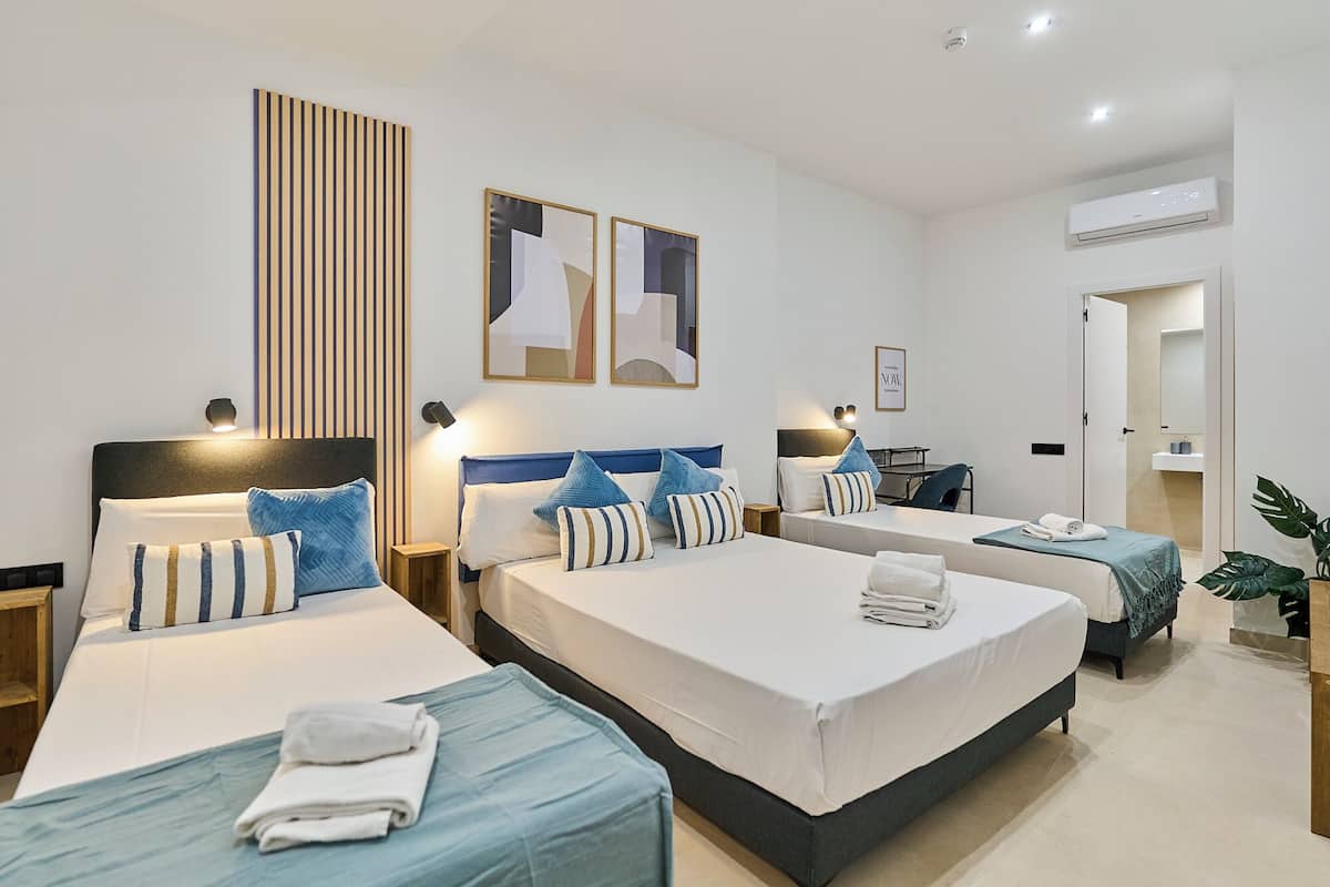 Une chambre d’hôtel avec deux lits, un bureau et une salle de bain.