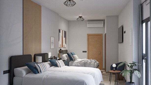 A modern bedroom with two beds, a wooden panel wall, a ceiling light, an air conditioner, and a large window. - Sant Adrià Urban Suites by gaiarooms (Badalona)