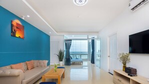 Una sala de estar moderna con sofá, mesa de centro y televisor.