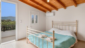 A bedroom with a bed, a balcony, a window, and a wooden ceiling.
