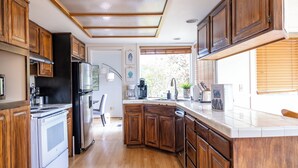 A kitchen with wooden cabinets, a stainless steel refrigerator, and a built-in oven.