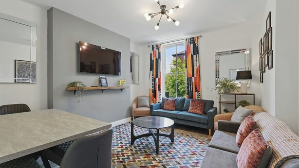 Una sala moderna con un sofá, una mesa de comedor y un televisor.