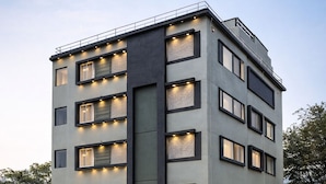 Een modern, meerhoog hotel met een opvallend bord, grote ramen en een plat dak.