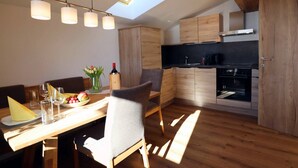 Une cuisine moderne avec des meubles en bois, un four encastré et une lucarne.