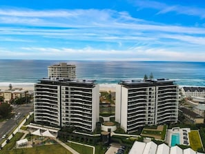 A high-rise hotel with multiple balconies, a central courtyard, and a view of the ocean. - Palm Beach Luxury Getaway (Palm Beach)