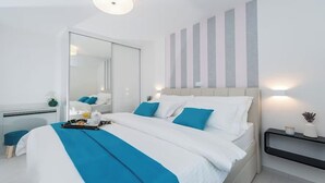 Ein modernes Hotelzimmer mit einem großen Bett, einem Nachttisch, einem Spiegel und einer Wand mit vertikalen Streifen.
