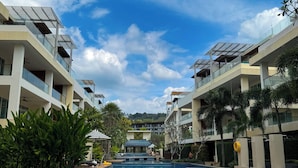 Et moderne hotel med swimmingpool, flere balkoner og solpaneler.